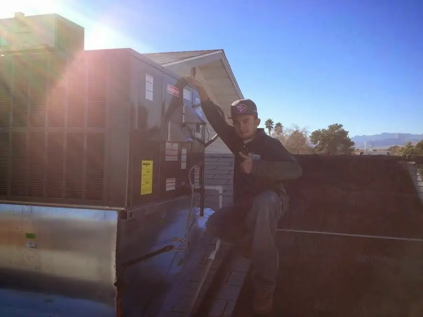 HVAC technician performing AC Tune-Up on a rooftop unit in Nipomo